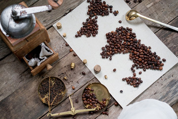 map of the world, coffee beans on old paper. Eurasia, America, Australia, Africa. vintage. Black coffee, ground coffee, scales, old Coffee grinder on wooden background . top view. flat lay