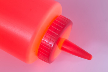 Yellow plastic ketchup bottle clloseup with a glowing light