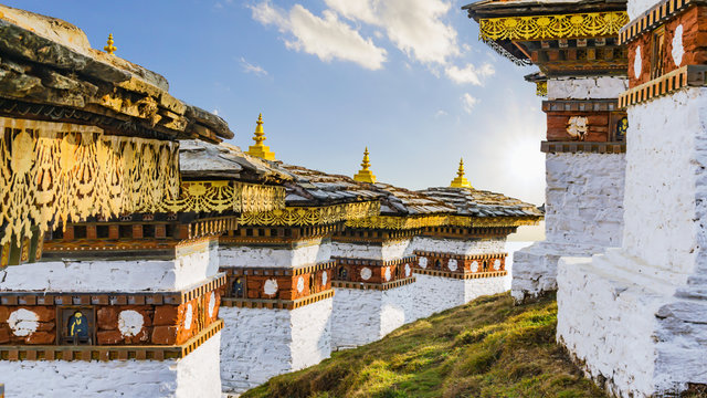 Dochula pass 108 chortens (Asian stupas) is the memorial in honour of the Bhutanese soldiers in the Timpu city with the grass landscape and cloudy sky background, Bhutan