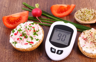 Glucometer and freshly sandwich with vegetables, diabetes and healthy nutrition