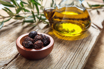 Bottle of olive oil and olives on a table