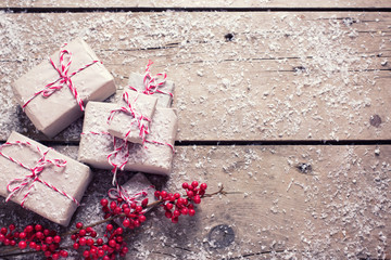 Wrapped christmas presents and decorative berries on aged wooden