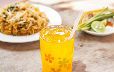 Orange juice in a glass with ice on wooden table