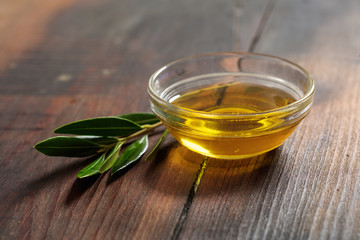 Olive oil and olive twig on a wooden table