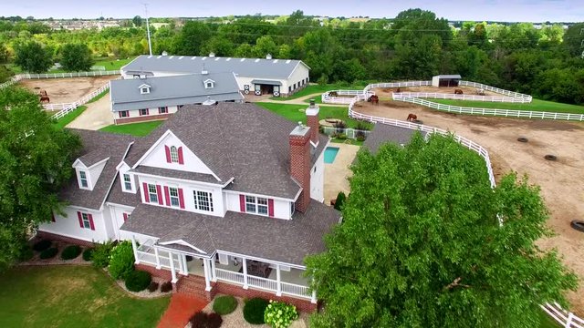 Country ranch, mansion with horse barns,pens,pool, aerial view.
