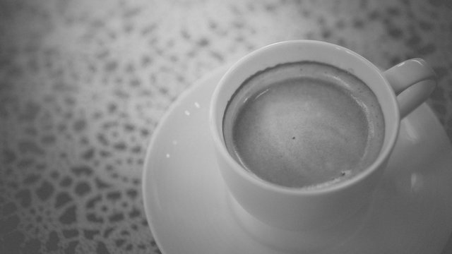 Cup of hot espresso coffee on table