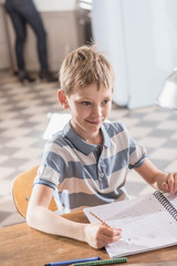 Focus on a young boy doing his school homework, at home