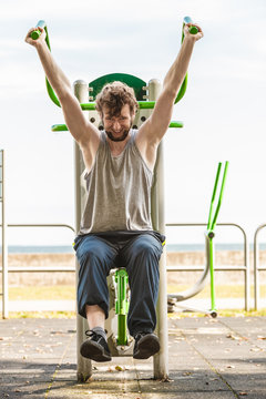 Active Man Exercising On Chest Press Outdoor.