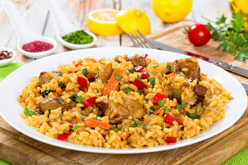 paella with meat, pepper, vegetables and spices on dish