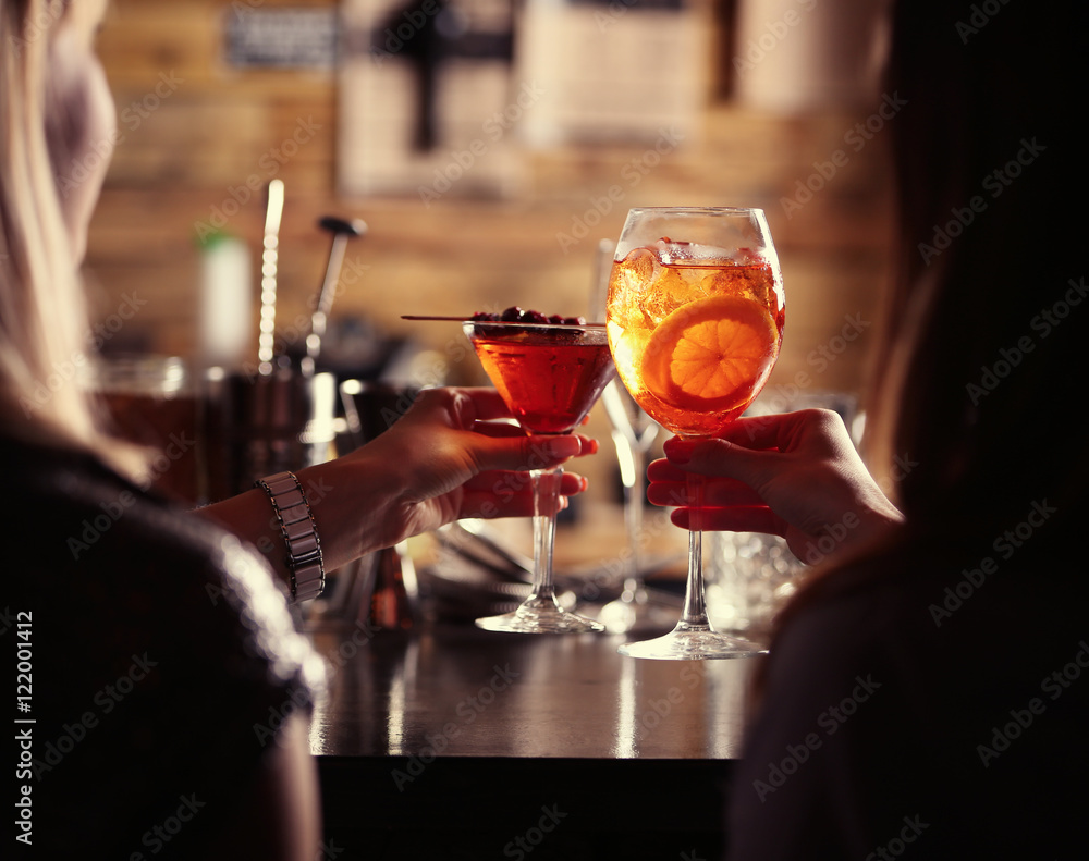 Poster Women toasting with cocktails in bar