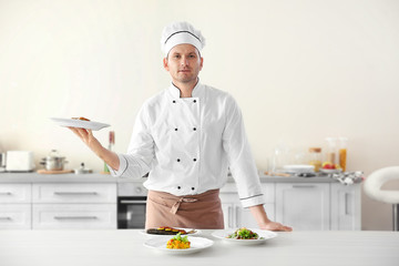 Young chef cook with different dishes in kitchen