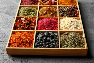 Different spices in wooden cells, closeup