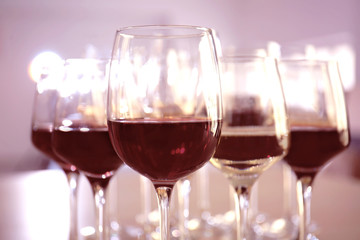 Glasses with red and white wine on table in restaurant