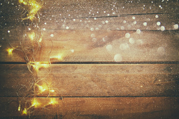 Fototapeta na wymiar Christmas gold garland lights on wooden rustic background