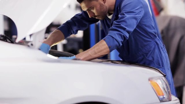 mechanic man with wrench repairing car at workshop 53