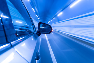 Speedy car driving in tunnel.