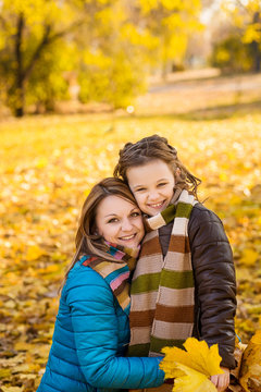 Mother and daughter have a walk in the autumn park