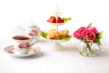 Cream puffs cakes or profiterole filled with whipped cream served with strawberries in plateau