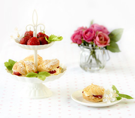 Cream puffs cakes or profiterole filled with whipped cream served with strawberries in plateau
