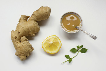 Ginger root, lemon, honey and fresh mint leaf on a white background