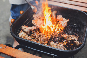 Grill steaks on metal grate with flame, barbecue