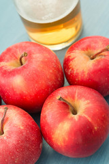 Ripe red apples with a glass of cider
