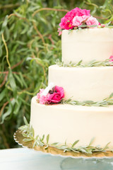 Beautiful wedding cake with flowers, outdoors. Three levels