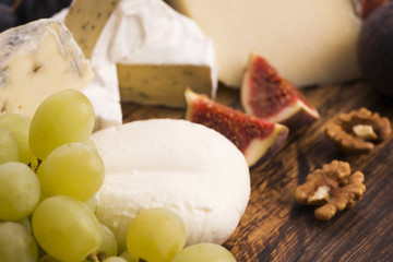 Assortment of cheese with fruits and grapes