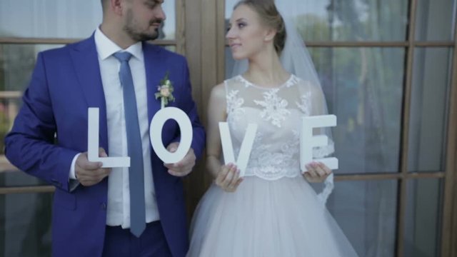 Newlyweds are holding the letter in his hands on a photo shoot