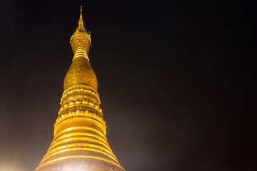 The top of Shwedagon pagoda at night with light up, famous sacred place in Yangon, Myanmar