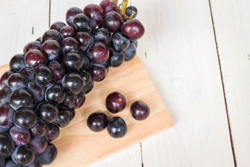 Ripe seedless grapes isolated on rustic wooden background