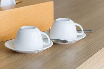 White cups coffee set on wooden table.