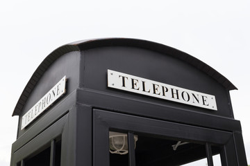 Vintage big black pay phone.