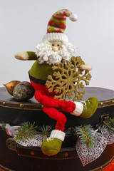 Santa Claus sits on vintage brown coffer with white christmas tree