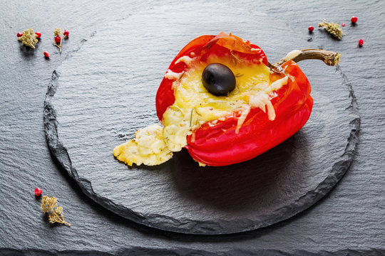 Stuffed Red Sweet Pepper With Feta Cheese  And Olives On Black Stone Background.