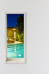 White wall window with swimming pool view.
