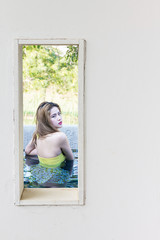 White wall window with sexy pretty woman in swimming pool view.