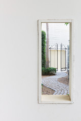 White wall window with walkway in garden view.
