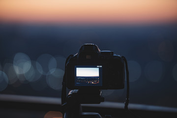 Digital camera on a tripod capturing the color of the city