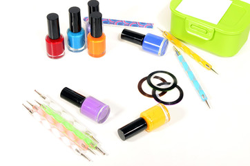 Obraz premium Table full of manicure ustensils, coloured nail polish,nail decals stickers, striping tape, nail file, dotting nail pens, vinyl sheets. Nails art accesories isolated on white. 