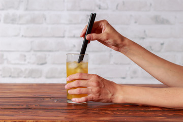 Girl in the restaurant drinking orange juice from a straw