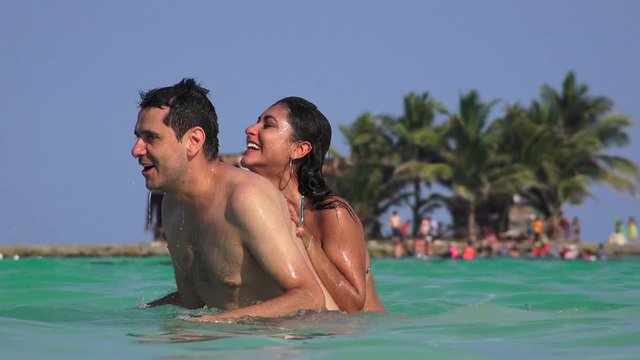 Man And Woman Having Fun Playing In Ocean Water On Summer Vacation