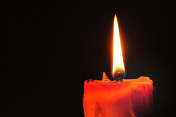 Red candle and lighting on black background