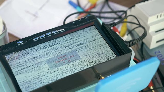 Close up of TV monitor screen with searching video signal to watch remote scene. Using device on drone control training fnd monitoring.
