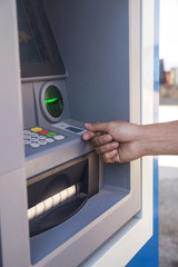 Close up of hand of a man using banking machine