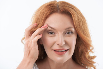 Fototapeta premium Cheerful middle-aged lady satisfied with skincare treatment