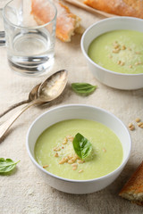 Green puree soup in white bowl