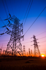 Fototapeta premium The silhouette of the evening electricity transmission pylon