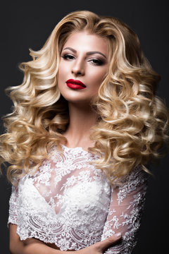 Beautiful blonde bride in wedding image with curls, red lips. Beauty face. Picture taken in the studio