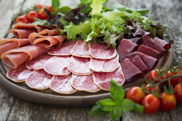 Antipasto with ham, salami and bresaola. tomato and basil. selec